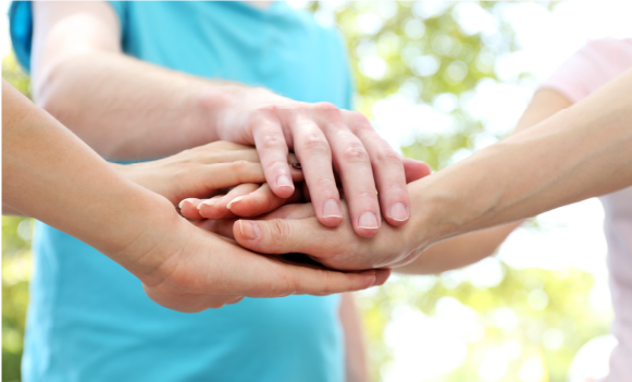 Przeplatające się dłonie, wskazujące na jedność.