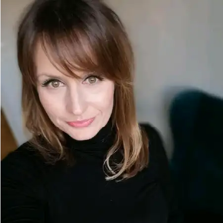 Eliza Istynowicz – psycholożka i trenerka, portret kobiety o blond włosach na czarnym tle